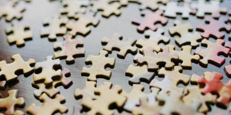 Des pièces de puzzle sont dispersées sur une table. Elles symbolisent des produits structurées.